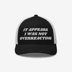 Overreacting Hat: A black-and-white mesh trucker cap with It Appears I Was Not Overreacting in raised white embroidery, symbolizing anti-fascist sentiment and progressive values.