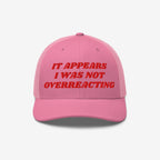 Pink trucker-style cap with red embroidered text: It Appears I Was Not Overreacting, symbolizing resistance against fascism and political gaslighting, supporting progressive activism and ACLU donations.