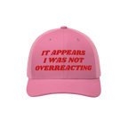 Pink trucker-style cap with red embroidered text: It Appears I Was Not Overreacting, symbolizing resistance against fascism a