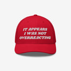 Red trucker-style Overreacting Hat with white embroidered text “IT APPEARS I WAS NOT OVERREACTING,” symbolizing anti-fascist sentiments, designed for progressives opposing extremism and political gaslighting.