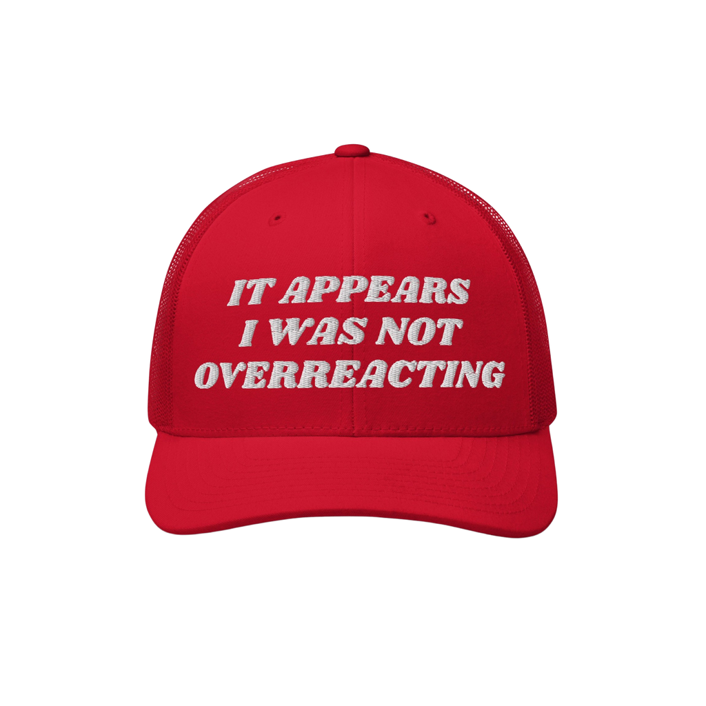 Red trucker-style Overreacting Hat with white embroidered text “IT APPEARS I WAS NOT OVERREACTING,” symbolizing anti-fasc