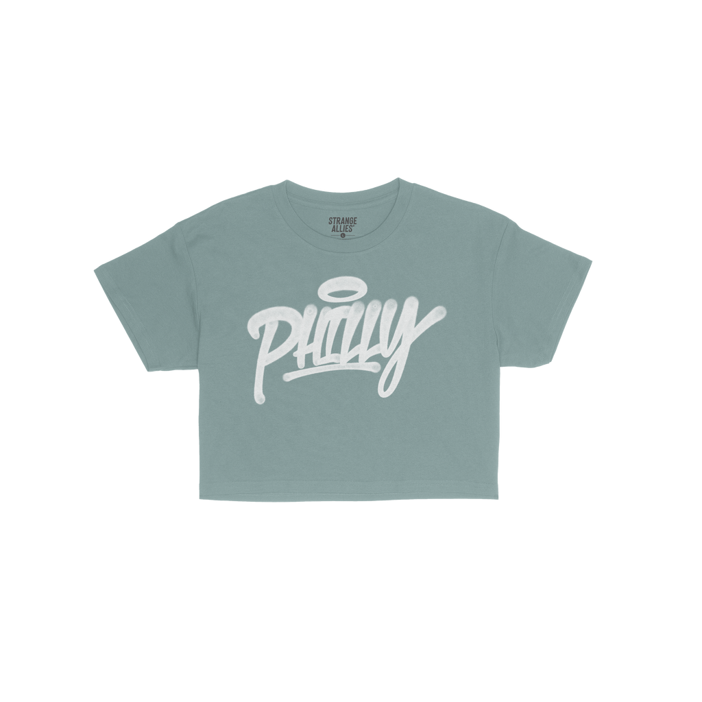 Philadelphia Handstyle Women's Baby Tee features a bold, graffiti-style Philly script with a halo motif on a royal-blue fabri