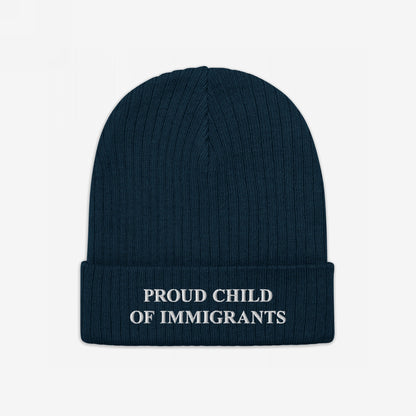 Navy-blue beanie with “PROUD CHILD OF IMMIGRANTS” in white embroidery on the cuff, symbolizing identity and heritage. The Proud Child Of Immigrants Hat embodies resilience and pride.