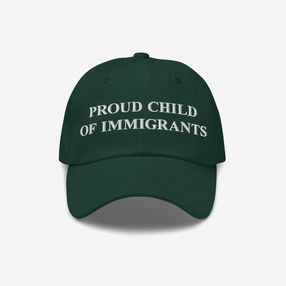 Dark green six-panel cap, PROUD CHILD OF IMMIGRANTS embroidered in white, symbolizing pride and resilience, reflecting the ethos of standing against injustice and celebrating identity.