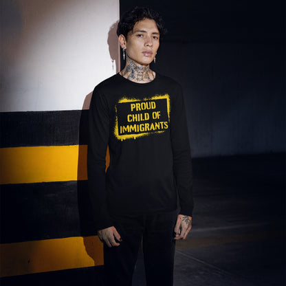 Young person in parking garage wearing Proud Child of Immigrants long-sleeve T-shirt, symbolizing strength and migration legacy, with tattoos, lip piercing, and earrings, embodying pride and cultural belonging.