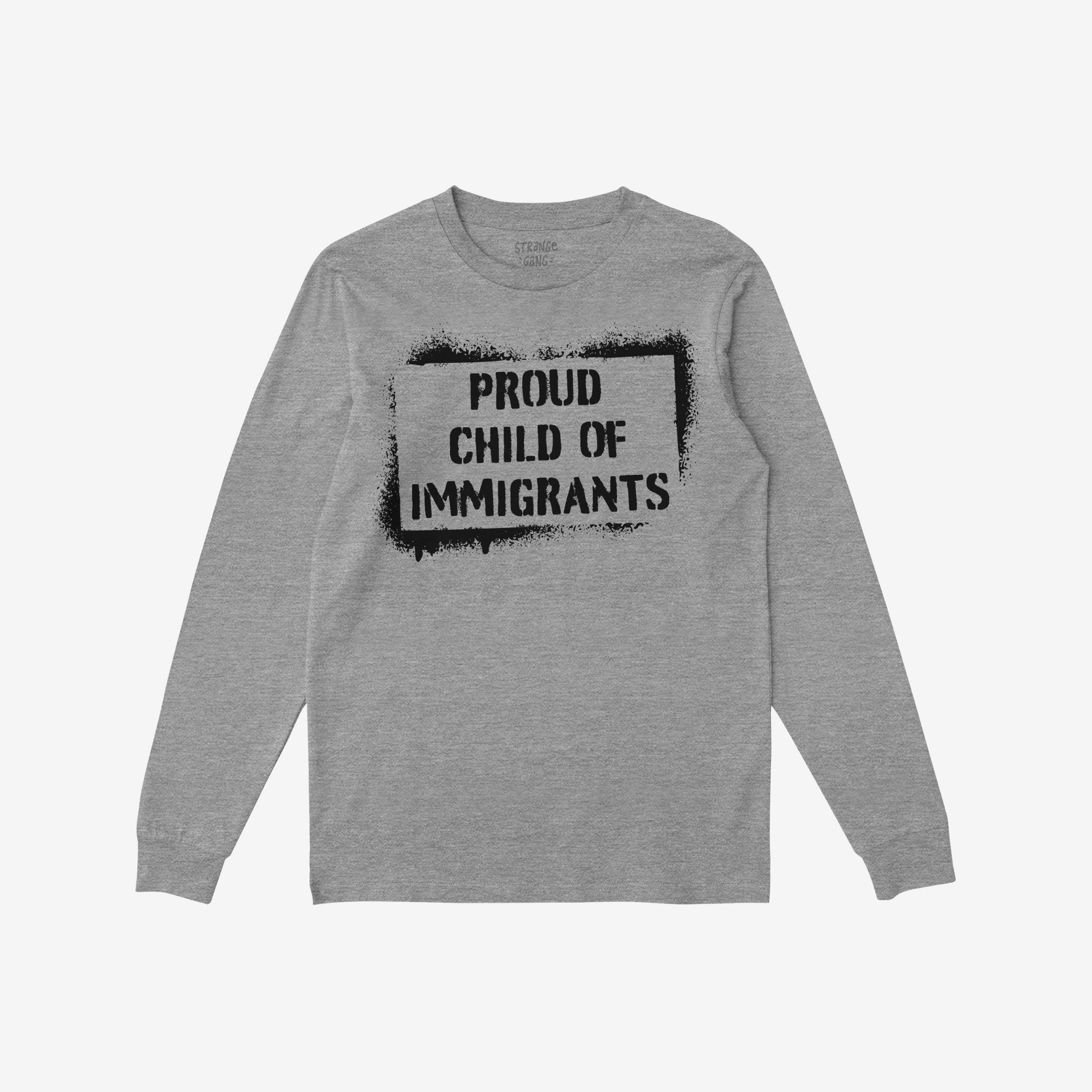 Proud Child Of Immigrants T-shirt: Light-gray, long-sleeve with bold, black stencil-style print, celebrating migration and cultural pride with the message PROUD CHILD OF IMMIGRANTS across the chest.
