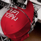 The Radical Left Hat in a machine, white thread stitches its message. This cap embodies progressive values and rebellion, blending hand-drawn embroidery with a defiant front panel statement.