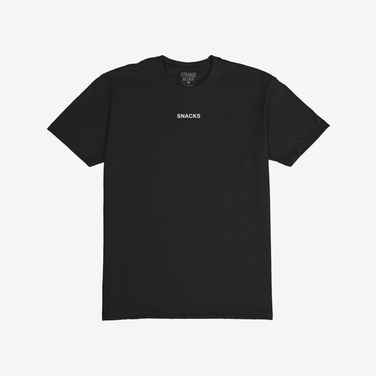 The Snacks T-shirt features the word SNACKS in white on a black tee, embodying a quirky, bold statement. Designed by STRANGE ALLIES, it reflects an unapologetic, playful attitude.
