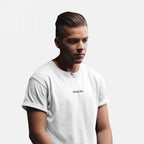Young man wearing the Snacks T-shirt, featuring small uppercase lettering on the chest. His slicked-back hair and relaxed pose complement the tee’s understated, cryptic vibe, perfectly embodying playful yet bold fashion.