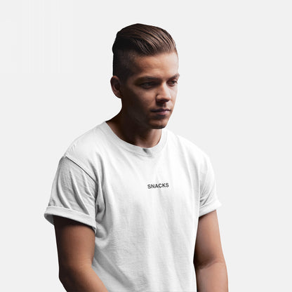 Young man wearing the Snacks T-shirt, featuring small uppercase lettering on the chest. His slicked-back hair and relaxed pose complement the tee’s understated, cryptic vibe, perfectly embodying playful yet bold fashion.