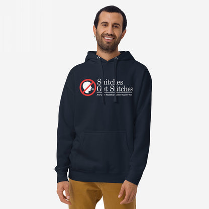 Snitches Get Stitches Hoodie: Model wears navy hoodie featuring a red no symbol over a speaking profile, with bold text Snitches Get Stitches and tagline critiquing healthcare, embodying dark humor and defiance.