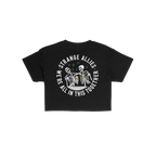 Social Club Women's Baby Tee features two skeletons clinking beer mugs, encircled by STRANGE ALLIES and WE'RE ALL IN THIS TOG