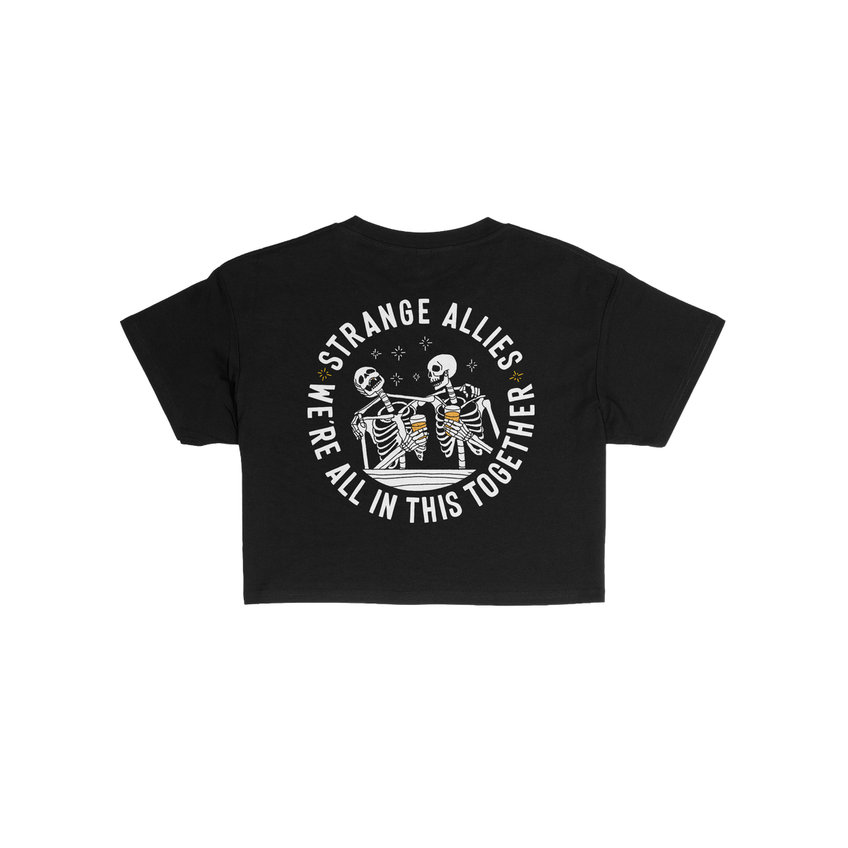 Social Club Women's Baby Tee features two skeletons clinking beer mugs, encircled by STRANGE ALLIES and WE'RE ALL IN THIS TOG