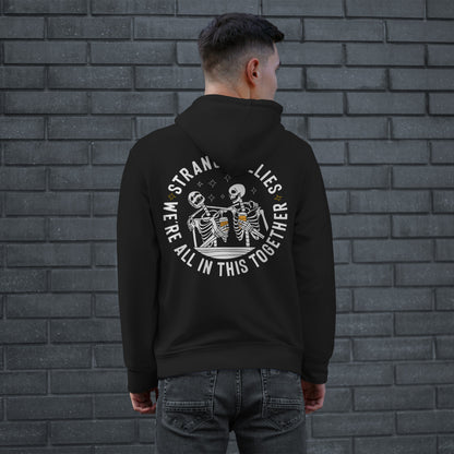 A person wearing the Social Club Hoodie & Sweatshirt with a bold back print of skeletons clinking mugs, signaling camaraderie with the slogans “STRANGE BUDDIES” and “WE’RE ALL IN THIS TOGETHER.”