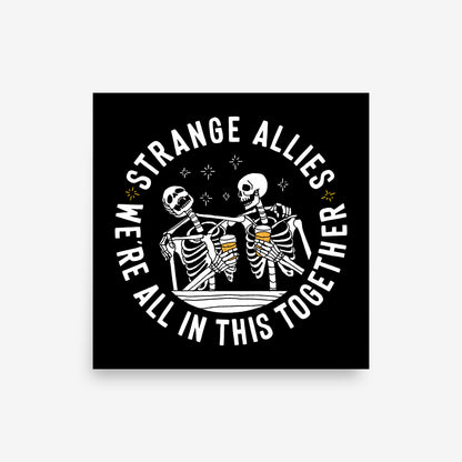 Social Club Giclée Print featuring two skeletons toasting with beer mugs, encircled by the phrase We're All in This Together, promoting inclusivity and camaraderie. Available in multiple square sizes.