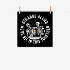 Social Club Giclée Print features two cartoon-style skeletons with beer glasses, surrounded by sparkles and the bold message, “WE’RE ALL IN THIS TOGETHER” on a square black background.