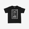 Still Here Women's Baby Tee features a bold white graphic of a resilient poppy growing from rubble, amidst falling debris, symbolizing strength against adversity. Ideal for protests and supporting human rights causes.
