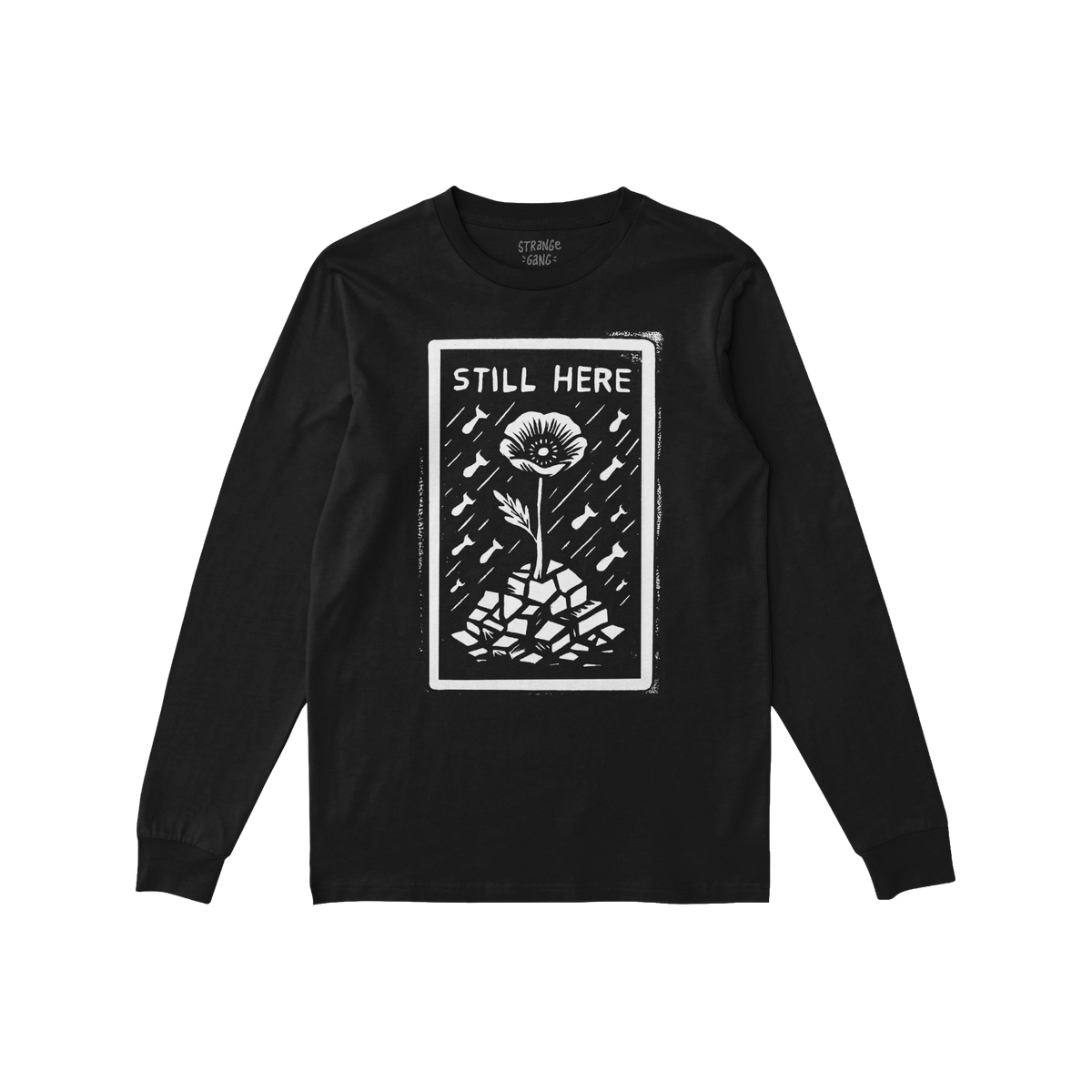 Still Here T-shirt features a striking protest design with 'STILL HERE' text above a single flower growing from rubble, symbo