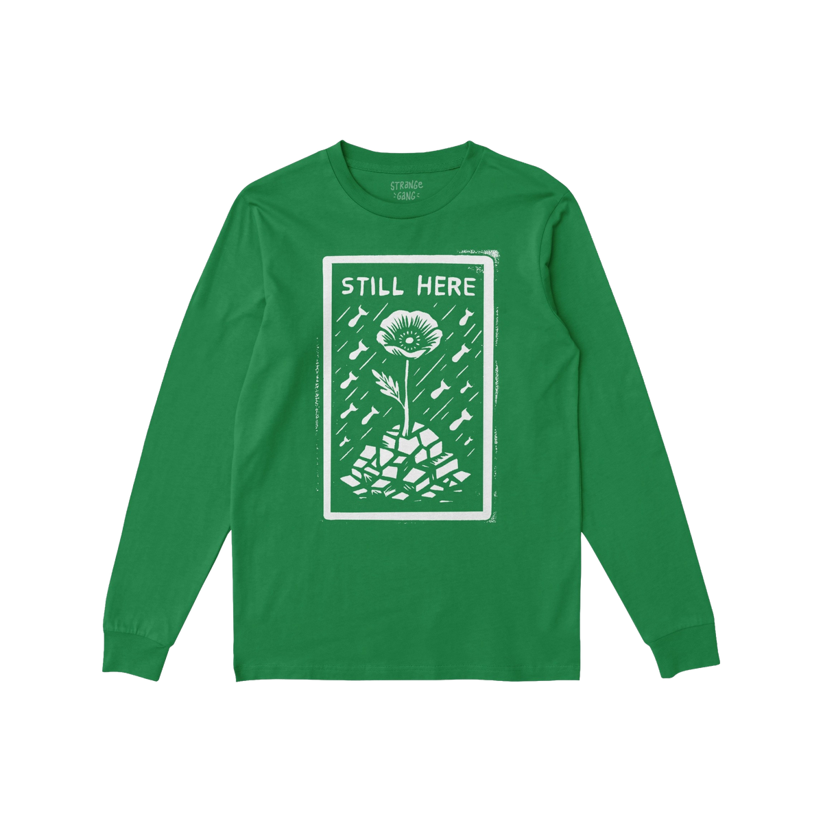 Still Here T-shirt: Green long-sleeve featuring a bold design with 'STILL HERE' text, a poppy flower emerging from rubble, su
