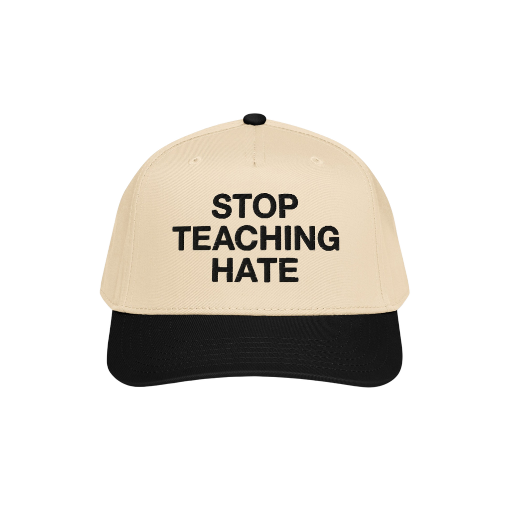 Two-tone baseball cap with a beige crown and black bill, featuring “STOP TEACHING HATE” in bold black letters, symbolizin