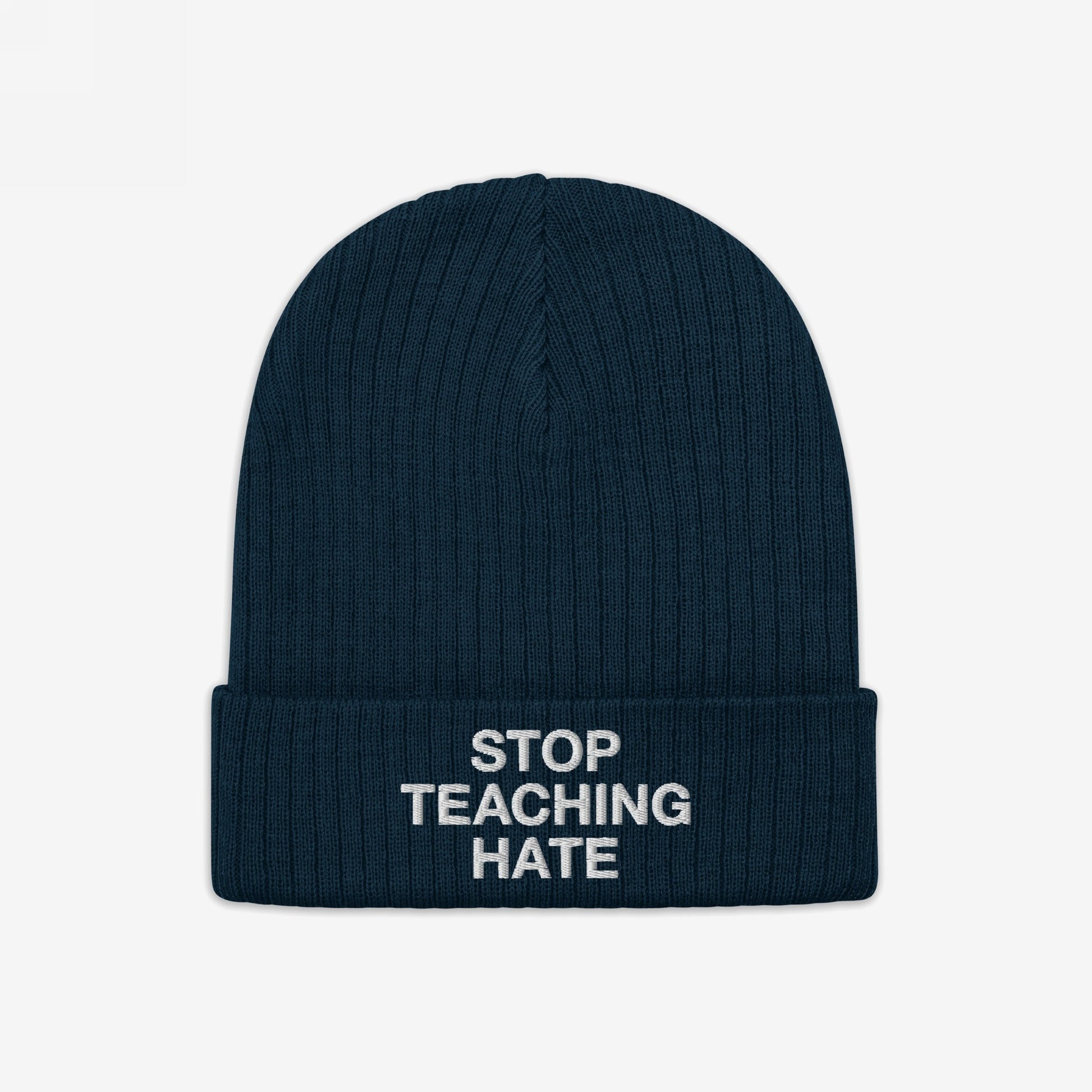 Dark navy-blue, rib-knit winter beanie with folded cuff featuring the bold slogan STOP TEACHING HATE in white lettering, embodying a strong visual protest against hate and promoting equality.