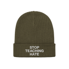 Olive-green knit beanie with a folded cuff featuring the bold statement STOP TEACHING HATE embroidered in white, embodying a 
