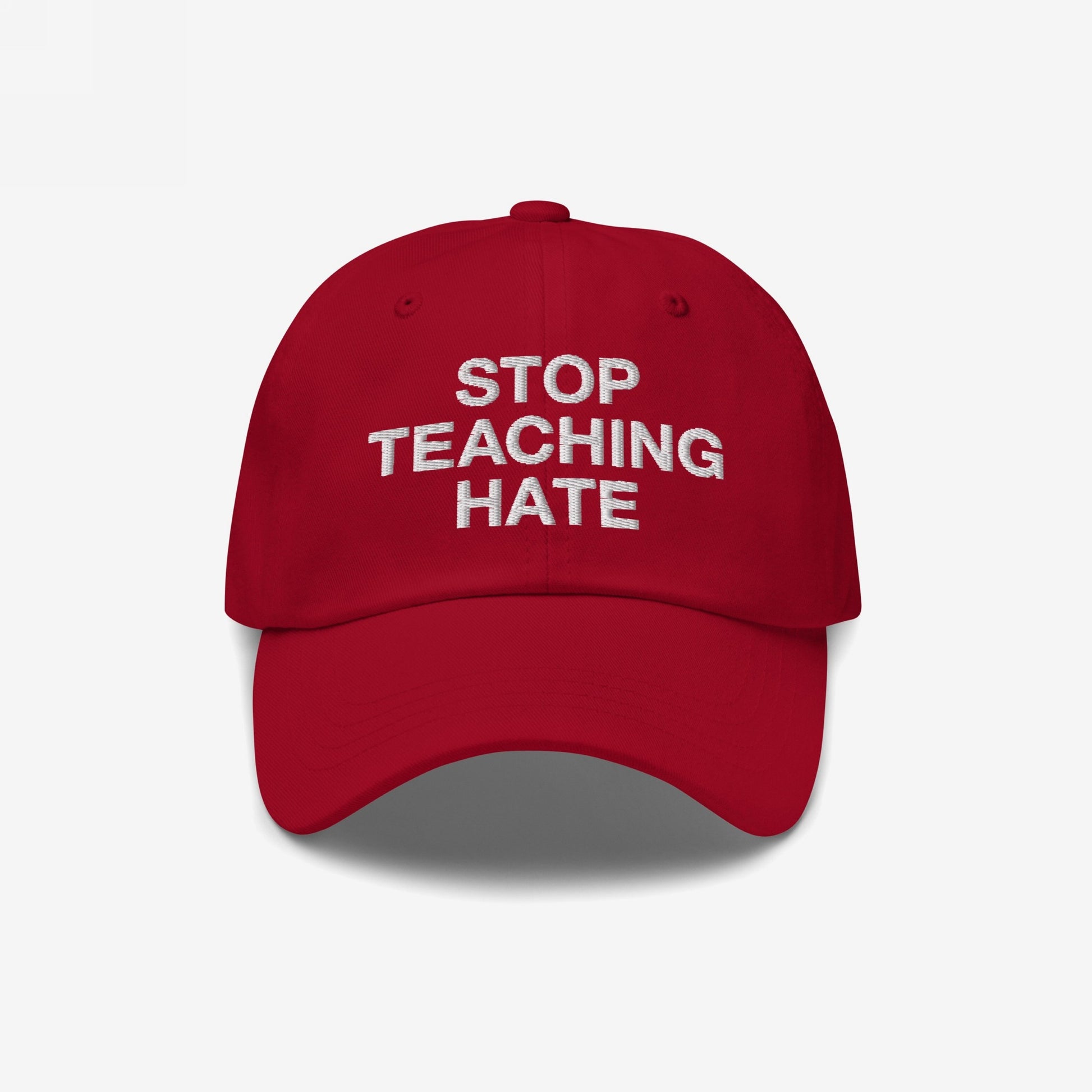 Red baseball-style cap with white embroidered text STOP TEACHING HATE, symbolizing a bold stance against hate. Ideal for those championing equality and inclusivity in everyday settings.