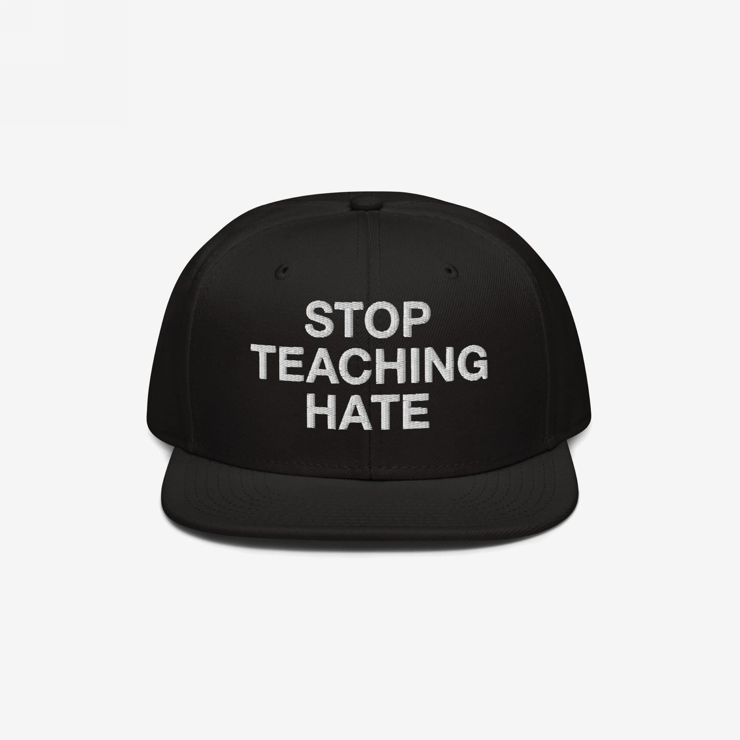 Black flat-brim snapback hat featuring the bold slogan “STOP TEACHING HATE” embroidered in white, embodying a visual protest message for equality and justice.