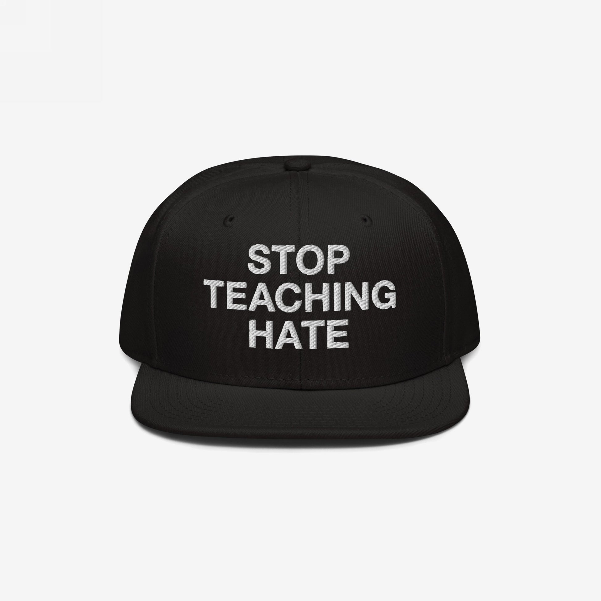 Black flat-brim snapback hat featuring the bold slogan “STOP TEACHING HATE” embroidered in white, embodying a visual protest message for equality and justice.