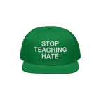 Green flat-brimmed baseball cap with STOP TEACHING HATE embroidered in white, symbolizing a bold stance against hate. Perfect