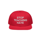 Red snap-back cap with STOP TEACHING HATE embroidered in white, embodying a bold stance against hate; designed for visibility