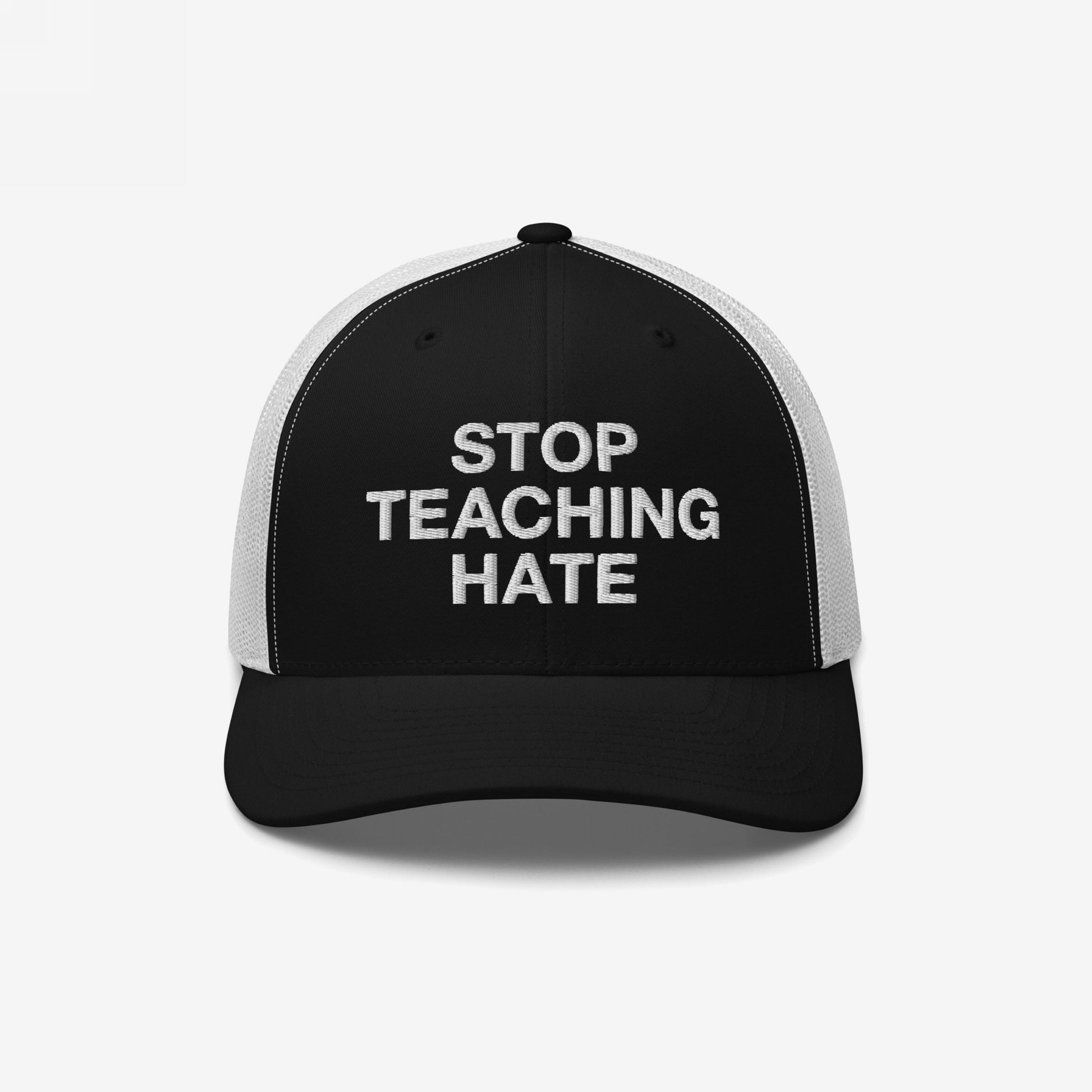 Black-and-white mesh-back baseball cap with STOP TEACHING HATE embroidered in white on the front panel, embodying a bold message of protest against hate and compliance.