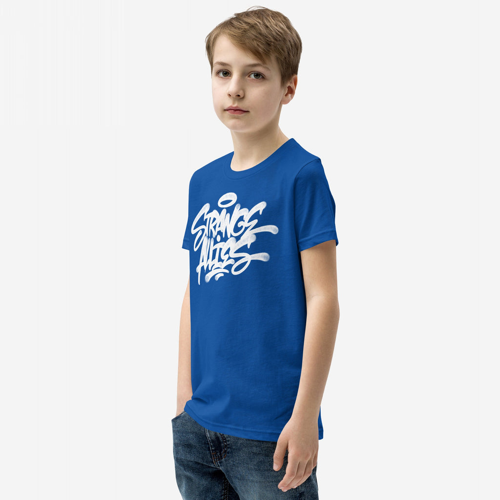 Boy in blue jeans wearing the Strange Allies Handstyle T-shirt, featuring bold graffiti-style lettering, embodying a rebellious spirit and sense of belonging.