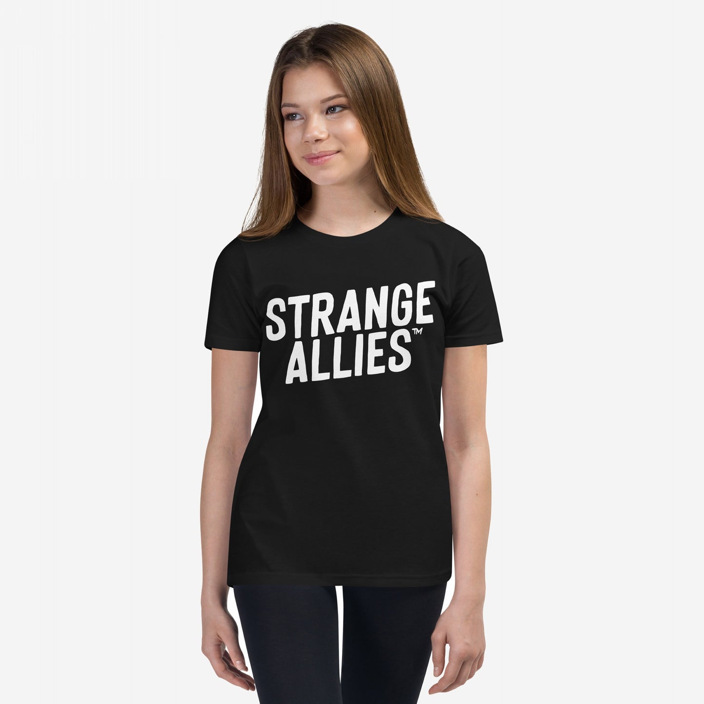 Young woman models the Strange Allies T-shirt with bold STRANGE ALLIES™ text, embodying a statement of inclusivity and individuality, reflecting the ethos of embracing outsiders and supporting equality.