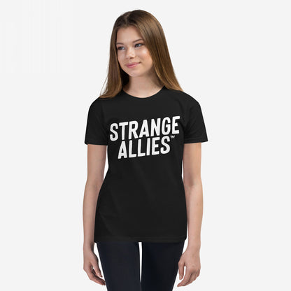 Young woman models the Strange Allies T-shirt with bold STRANGE ALLIES™ text, embodying a statement of inclusivity and individuality, reflecting the ethos of embracing outsiders and supporting equality.