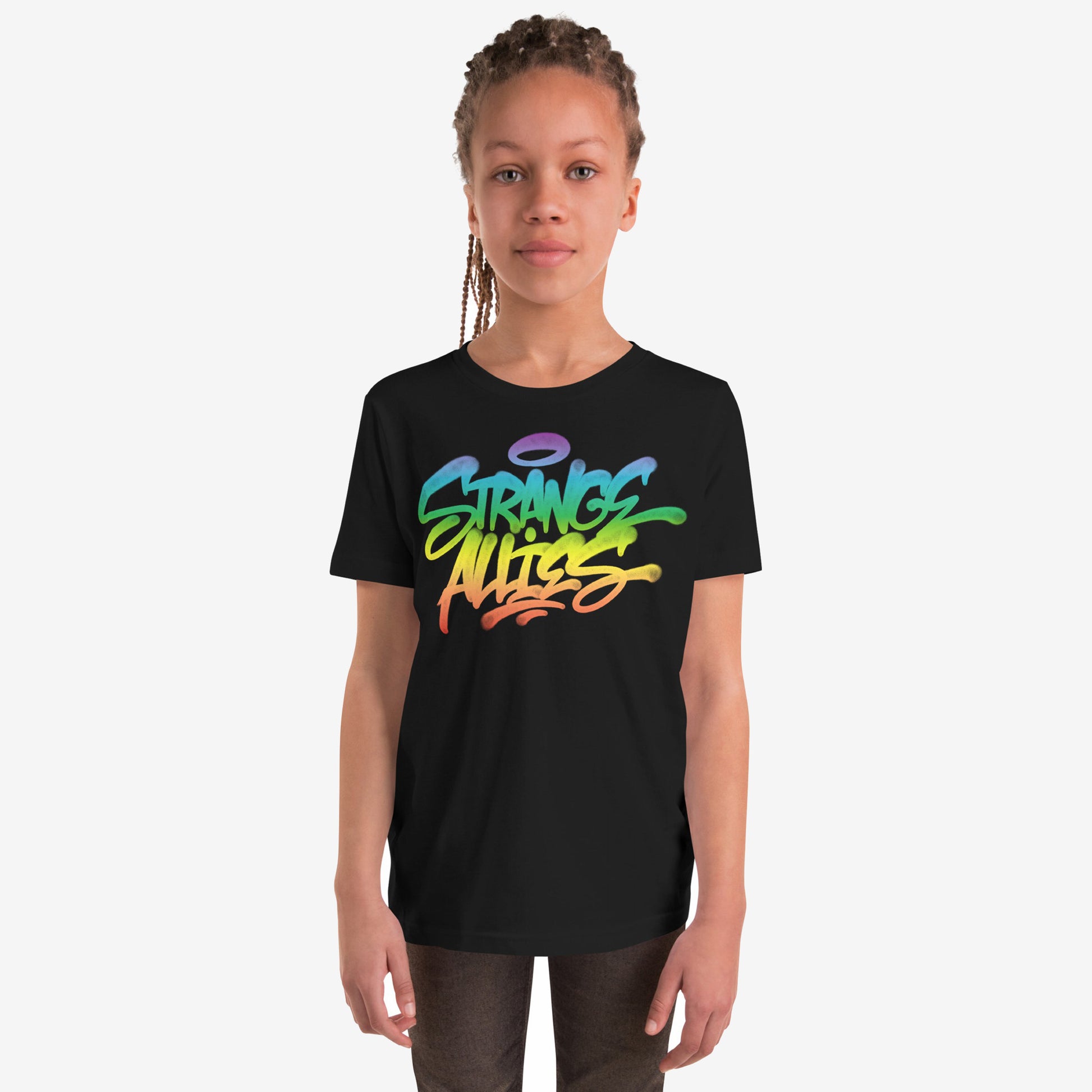 Young person wearing the Strange Allies Rainbow Handstyle T-shirt featuring a vibrant graffiti design with STRANGE ALLIES text, embodying bold individuality and inclusivity. The tee is paired with dark pants.