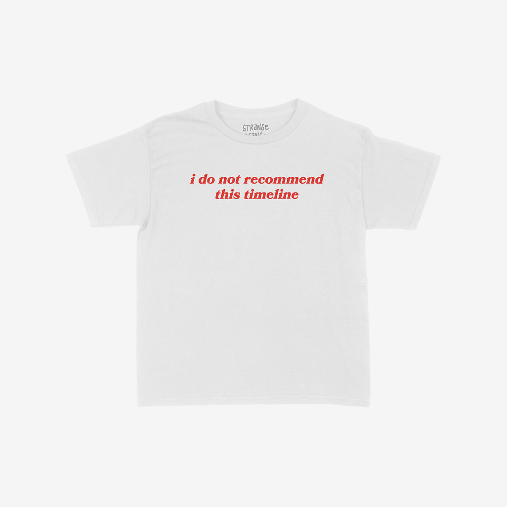 Timeline Women's Baby Tee features bold red text, i do not recommend this timeline, on a cropped white T-shirt, reflecting minimalist sarcasm and a statement on navigating modern reality.