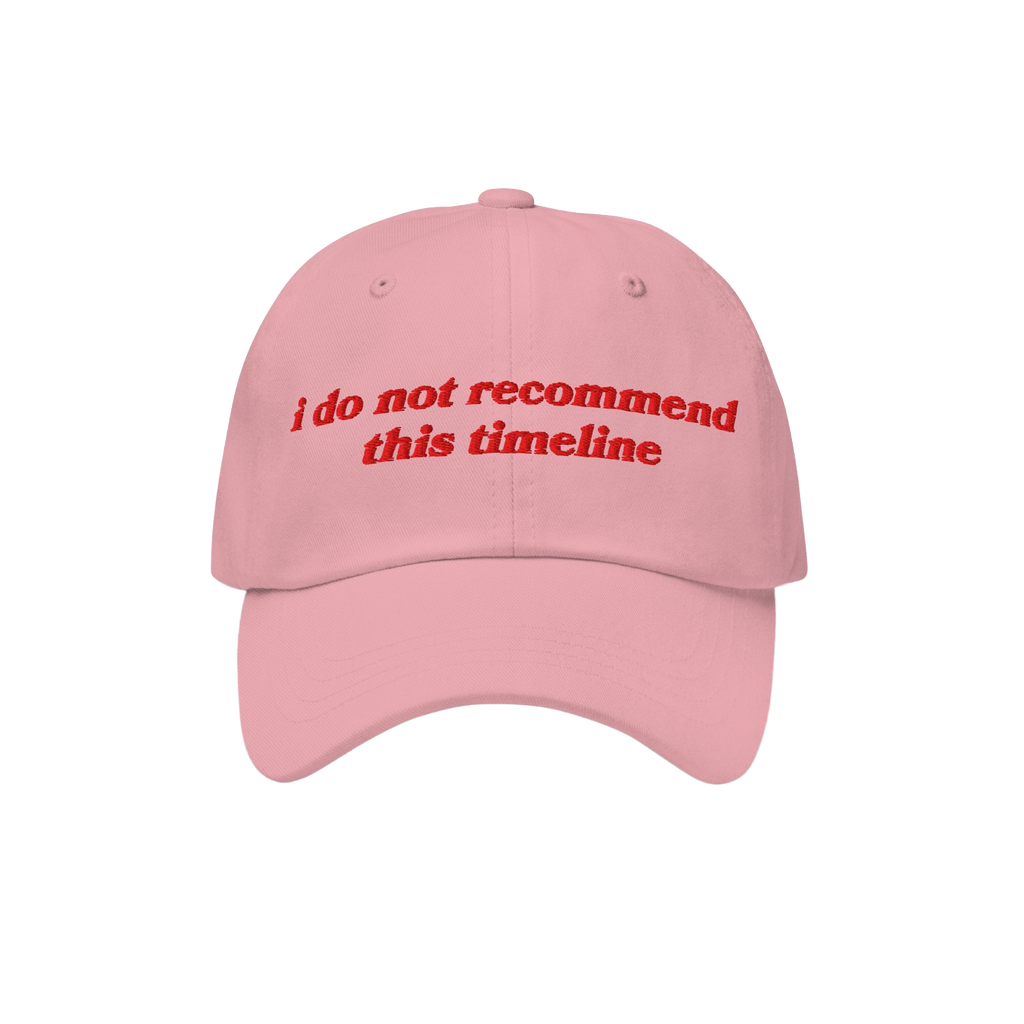 Light pink Timeline Hat with red embroidery stating, “i do not recommend this timeline,” reflecting political humor and i