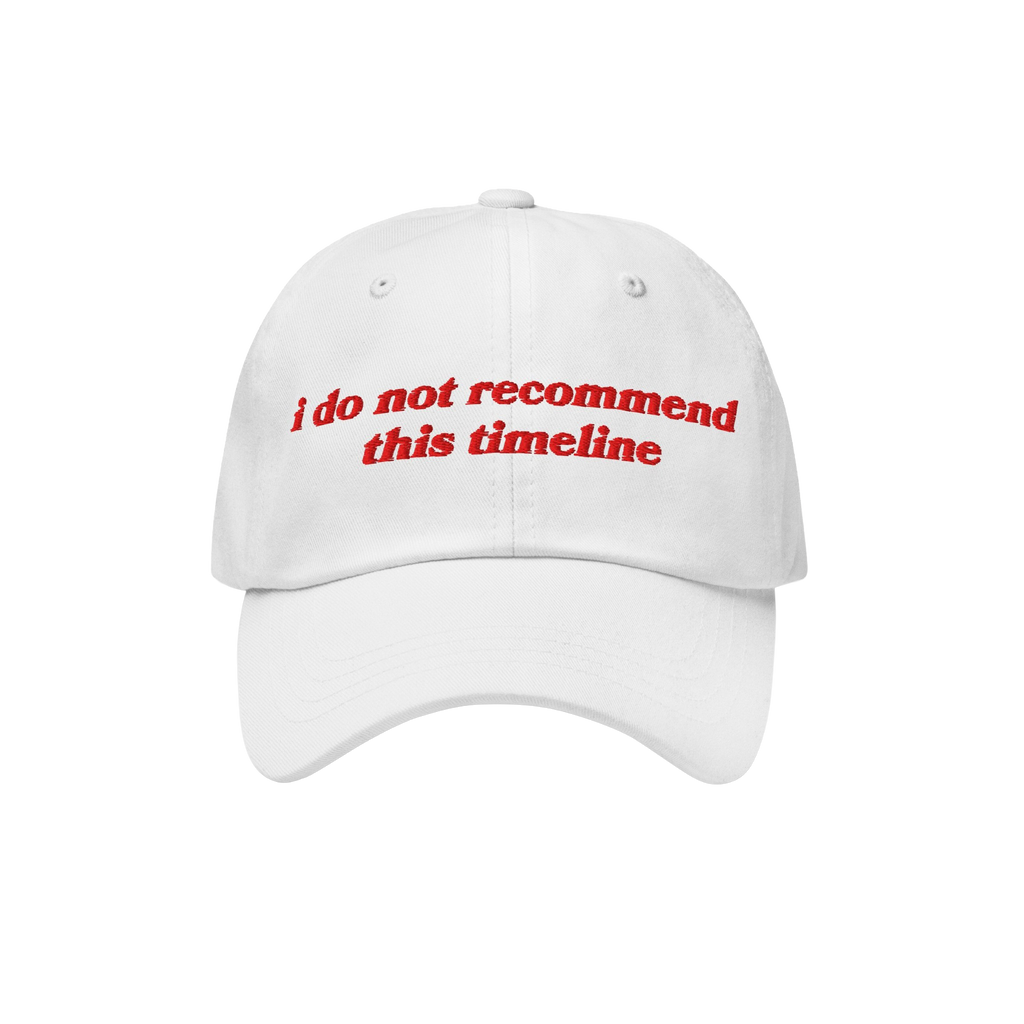 White six-panel baseball cap with red embroidery reading i do not recommend this timeline, reflecting political irony and hum