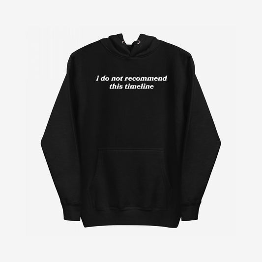 The Timeline Hoodie features a black pullover with I do not recommend this timeline in white serif text across the chest, capturing a sharp, minimalist style with a touch of sarcasm.
