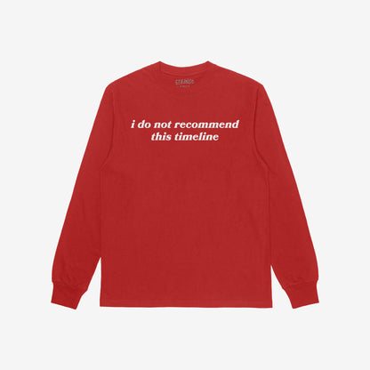 Red long-sleeve crewneck T-shirt with i do not recommend this timeline in white serif lettering, showcasing sarcastic style and existential commentary, known as the Timeline T-shirt.