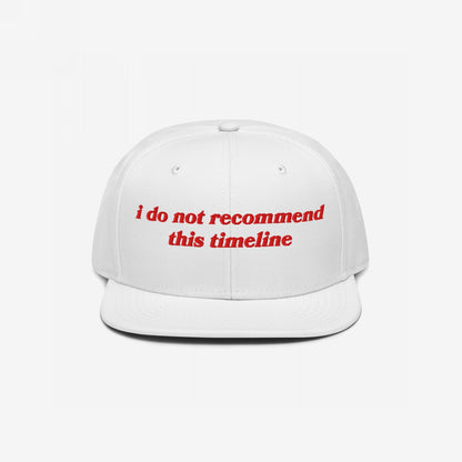 White Timeline Hat with red vintage-inspired embroidery stating “i do not recommend this timeline.” Perfect for expressing political discontent with style, available in various styles like snapback and beanie.