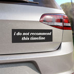 The back of a silver hatchback displays the Timeline Sticker & Magnet with the phrase, “i do not recommend this timeline,” on a black bumper sticker, highlighting existential humor.