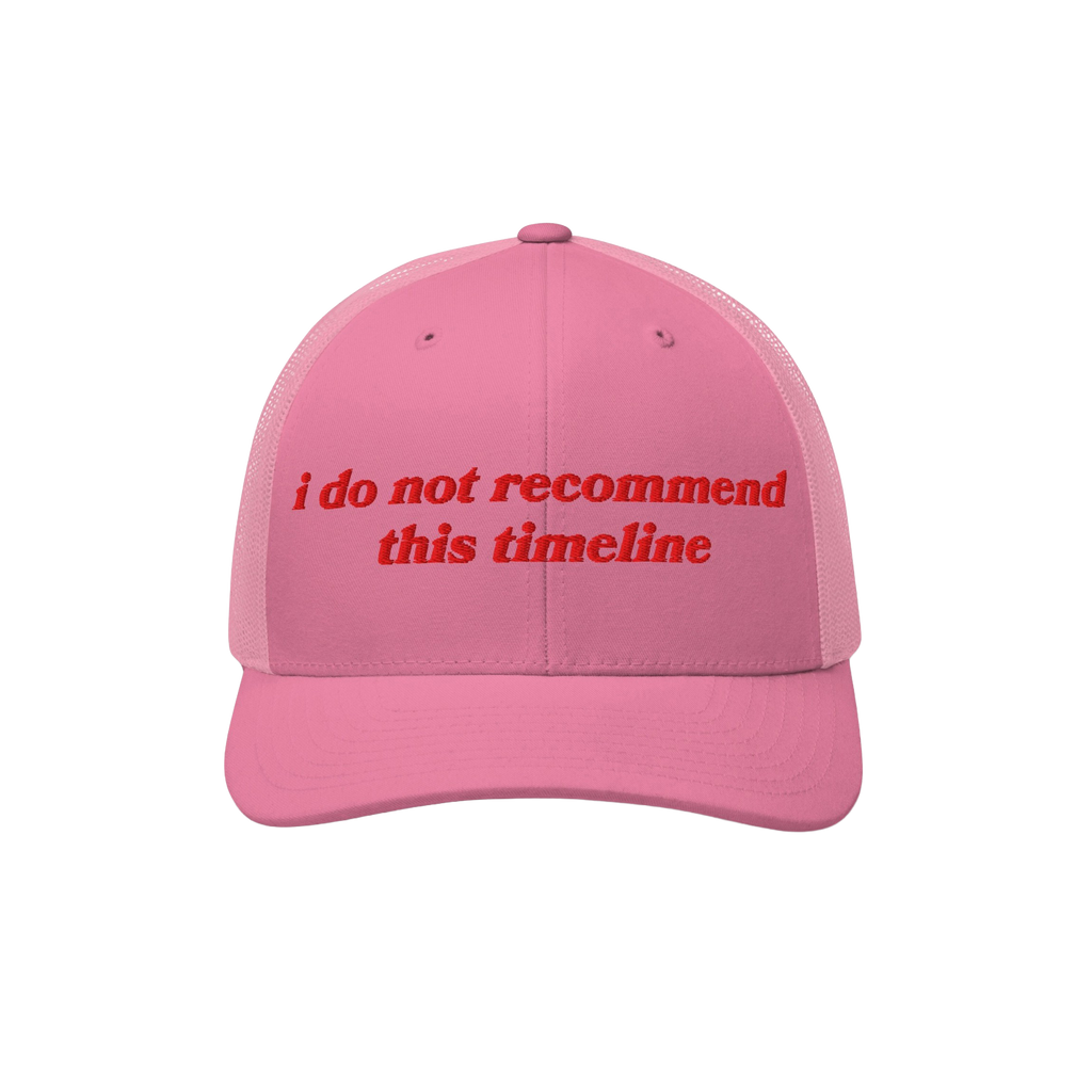 Pink mesh-back trucker hat with red embroidered text i do not recommend this timeline, humorously reflecting political irony.