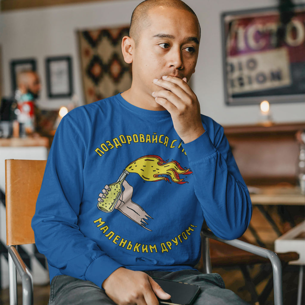 Young man in a café wears the Say Hello Ukraine Shirt, featuring a cartoon Molotov cocktail and Cyrillic text, symbolizing resistance and supporting Ukraine's fight for democracy and equality.