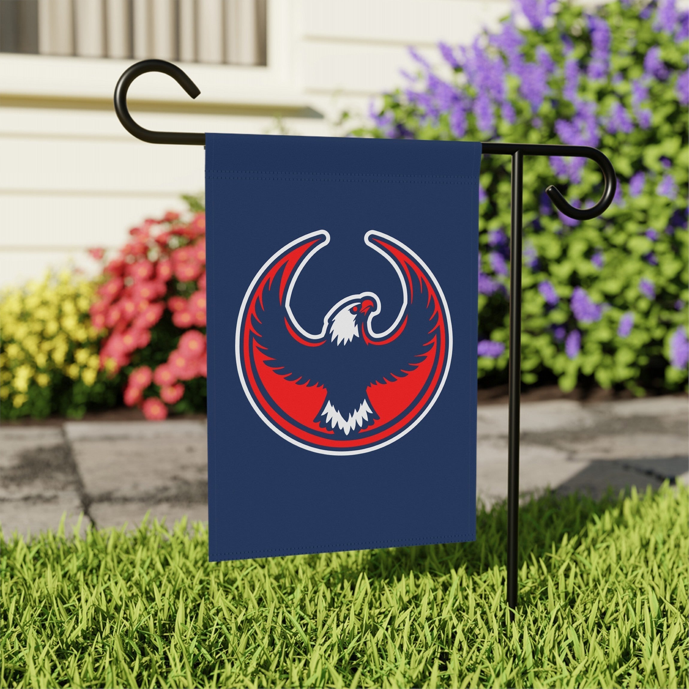 USA Rebel Alliance Garden Flag on a black metal stake in a grassy yard, featuring a stylized eagle emblem. Perfect for expressing anti-fascist and immigrant rights support outdoors.