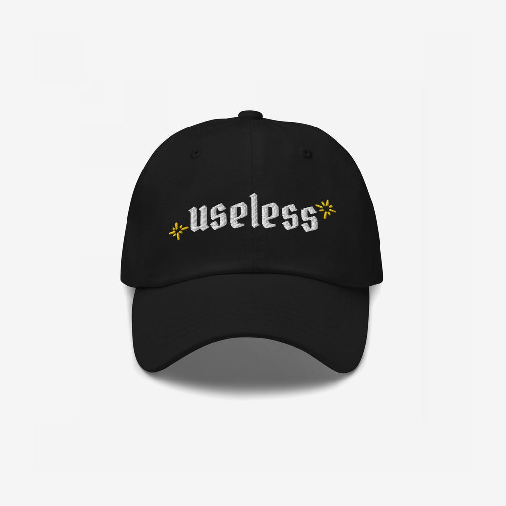 Black Useless Hat with “useless” in white embroidery and yellow star accents, symbolizing rest and reflection. Available in multiple styles, embracing a relaxed, unapologetic lifestyle.