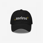 Black Useless Hat with “useless” in white embroidery and yellow star accents, symbolizing rest and reflection. Available in multiple styles, embracing a relaxed, unapologetic lifestyle.