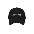 Black Useless Hat with “useless” in white embroidery and yellow star accents, symbolizing rest and reflection. Available 