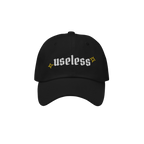 Black Useless Hat with “useless” in white embroidery and yellow star accents, symbolizing rest and reflection. Available 